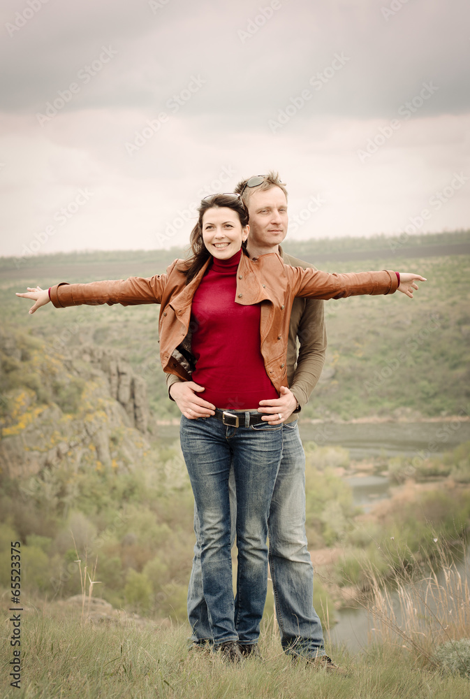 Attractive happy couple posing in the wilderness Attractive happy couple posing in the wilderness
