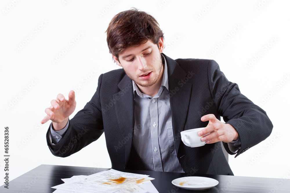 Young businessman spills coffee for documents Young businessman spills coffee for documents