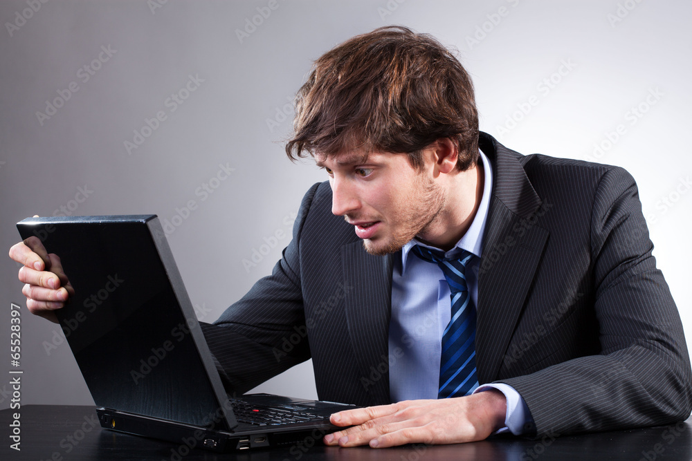 Businessman siting at his desk and looking at computer Businessman siting at his desk and looking at computer