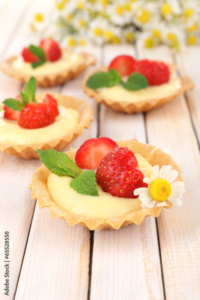 Tasty tartlets with strawberries on table close-up