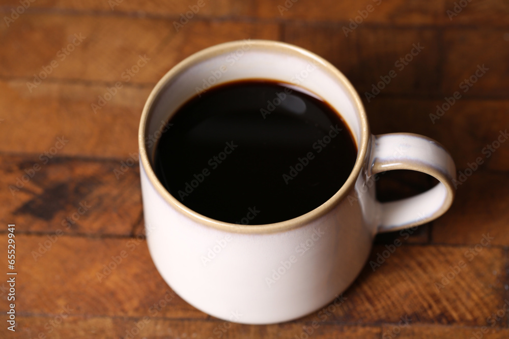 Cup with hot coffee on wooden background