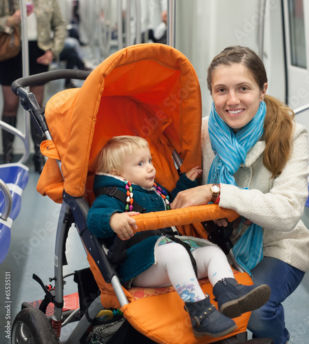 Фотография woman with child in stroller at metro