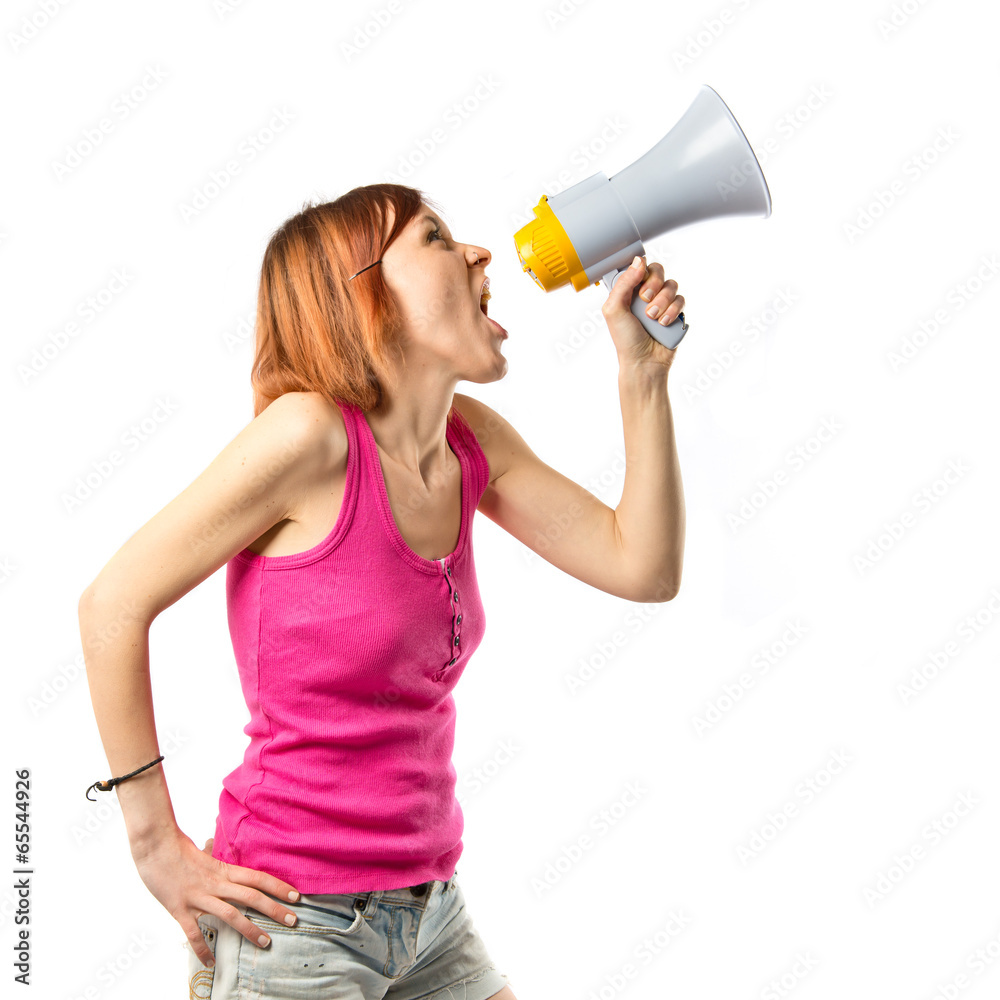 Redhead girl shouting with a megaphone over white background Redhead girl shouting with a megaphone over white background