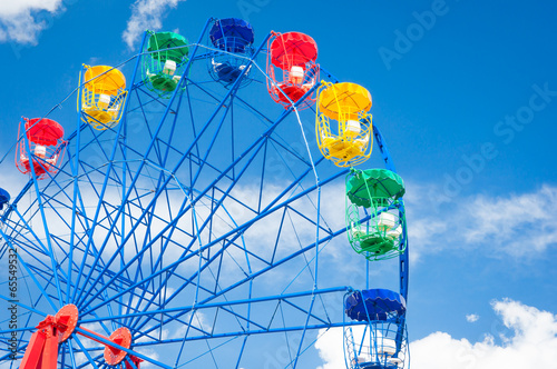 Giant ferris wheel against blue sky and white cloud