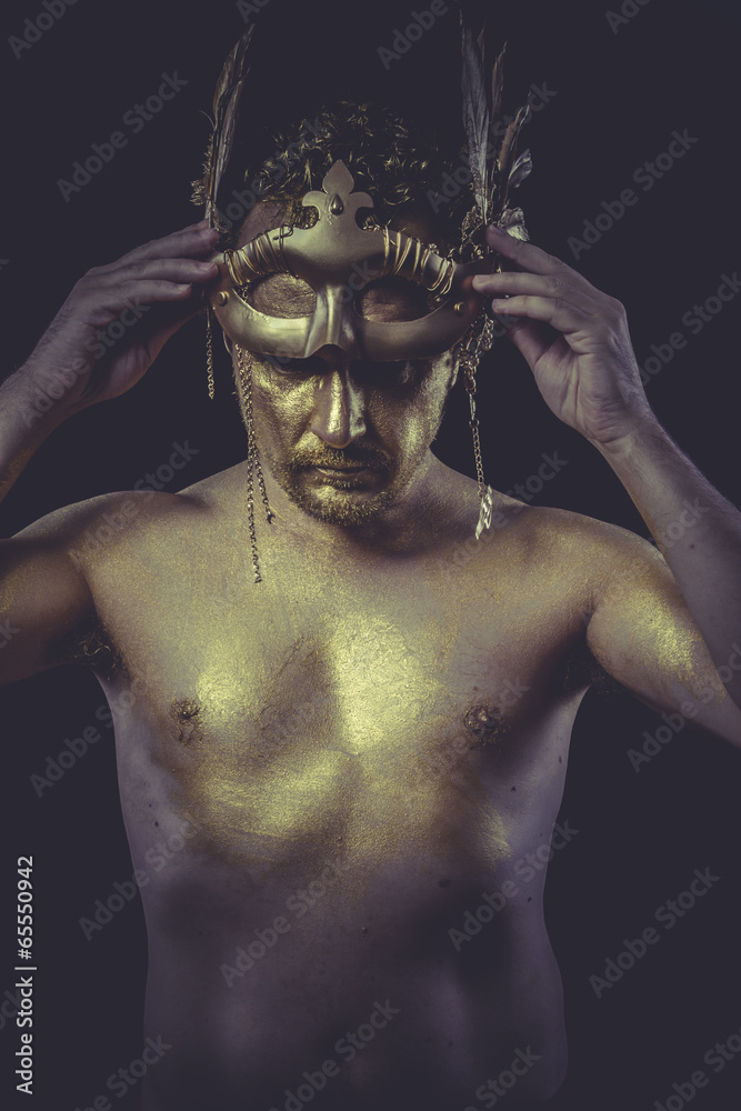 Golden, Man with body painted gold feather mask and steel sword