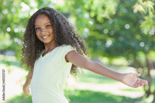 Tablou pe pânză Young girl smiling at the camera with arms outstretched