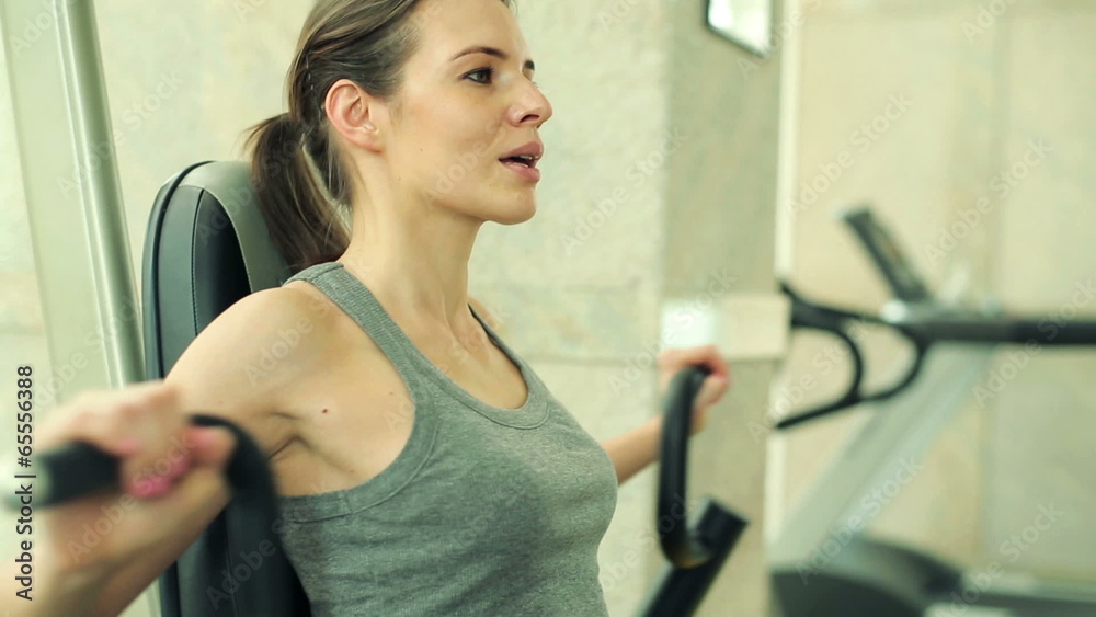 Young woman exercising on rowing machine in the gym Young woman exercising on rowing machine in the gym