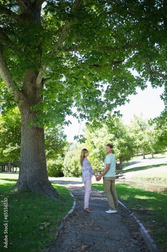 Cute affectionate couple walking hand in hand in the park