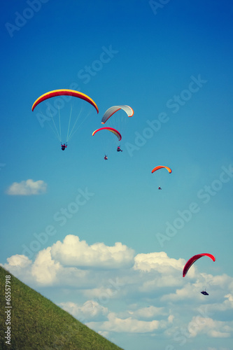 Paraglider flying against the czech central mountains