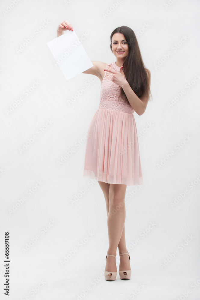 Woman in pink dress pointing on place copy Woman in pink dress pointing on place copy