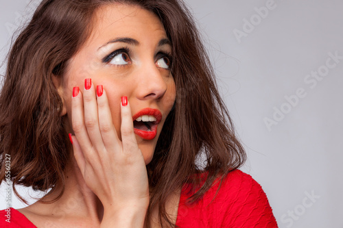 Surprised sexy brunette with red dress