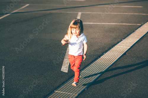 Little girl running away on the road