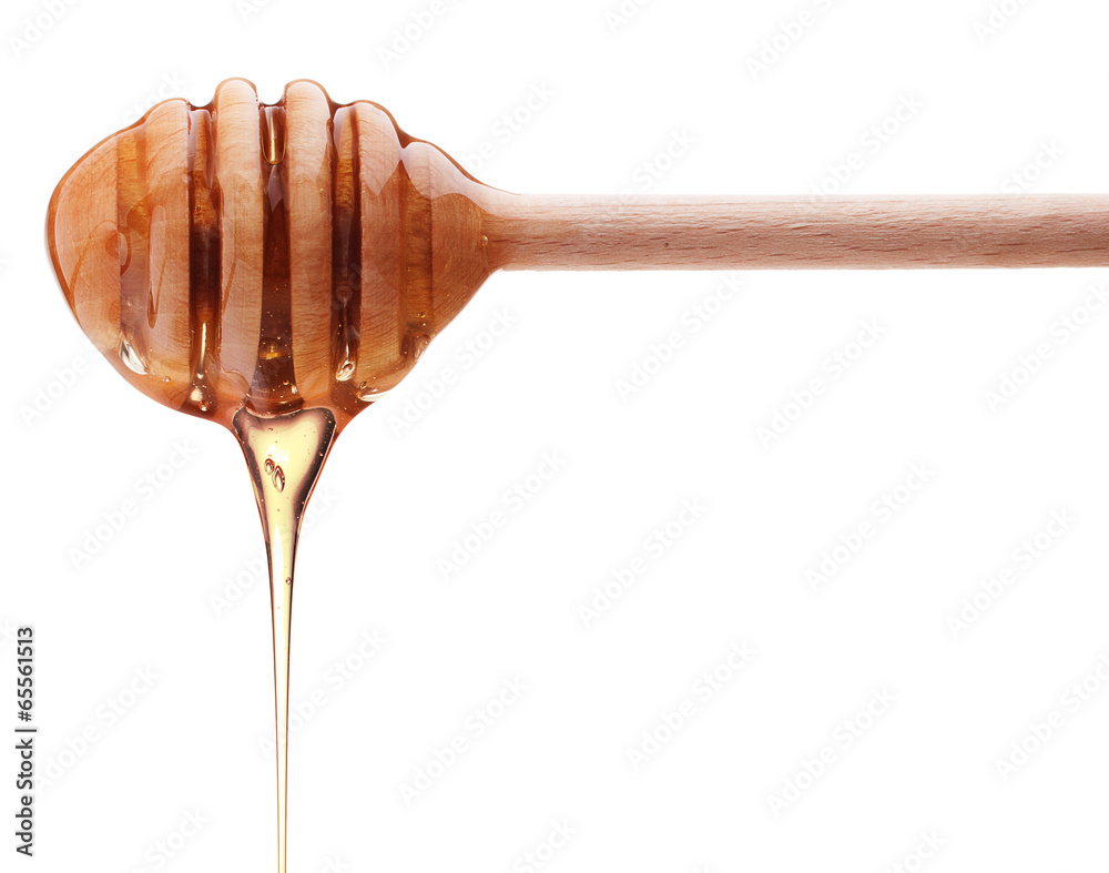 Honey dripping from a wooden honey dipper isolated on white back Honey dripping from a wooden honey dipper isolated on white back
