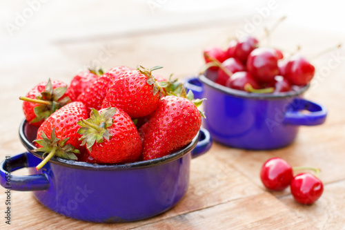 Strawberries and cherries in rustic pots