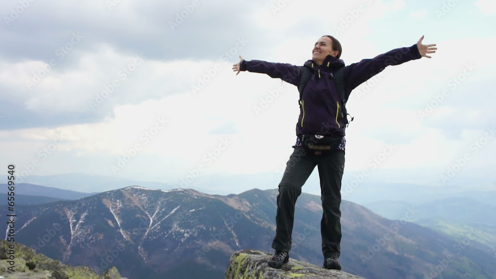 Successful woman raising hands on the top of mountain Successful woman raising hands on the top of mountain