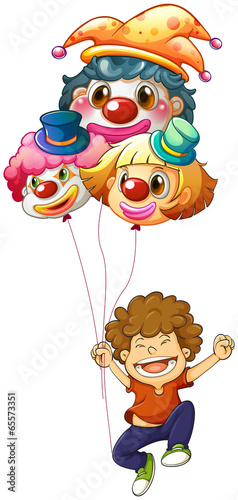 A happy boy with three clown balloons