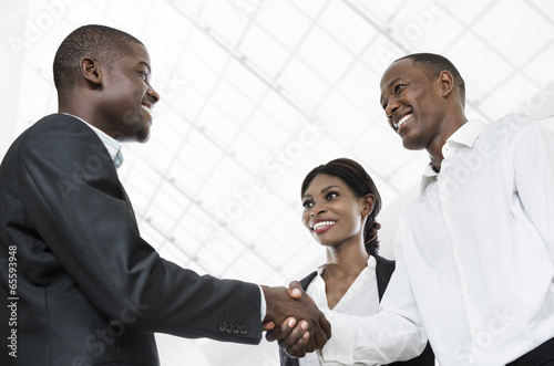 Three african business people handshake
