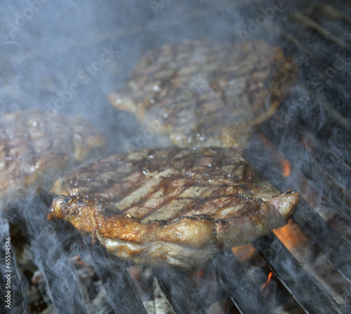 beef steak cooking on an open flame grill