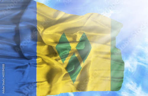 Saint Vincent and Grenadines waving flag against blue sky with s photo