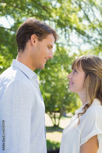 Attractive couple smiling at each other in the park