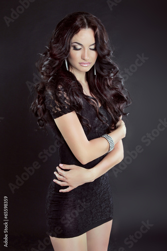 Sensual brunette woman Model with long curly hair, in dress, iso