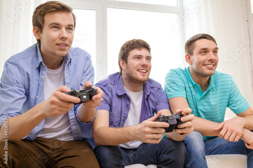 smiling friends playing video games at home