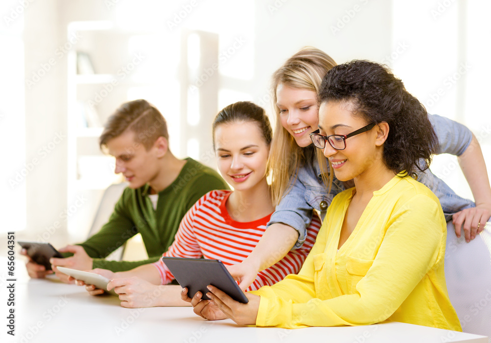 smiling students looking at tablet pc at school smiling students looking at tablet pc at school