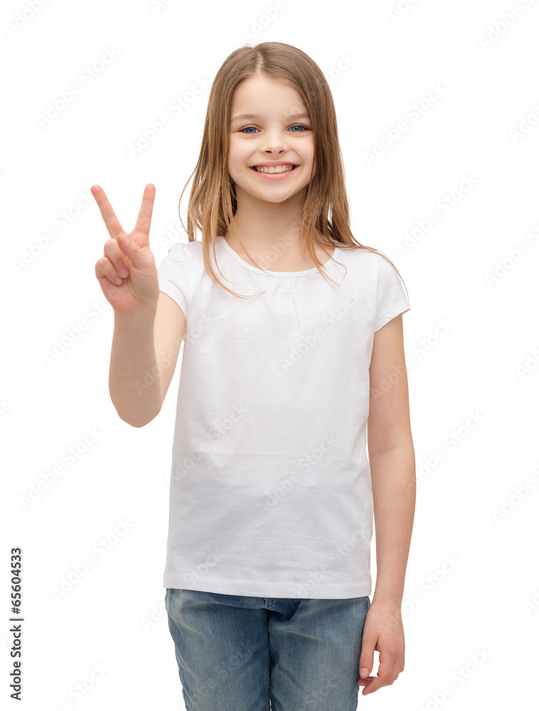 little girl in white t-shirt showing peace gesture little girl in white t-shirt showing peace gesture
