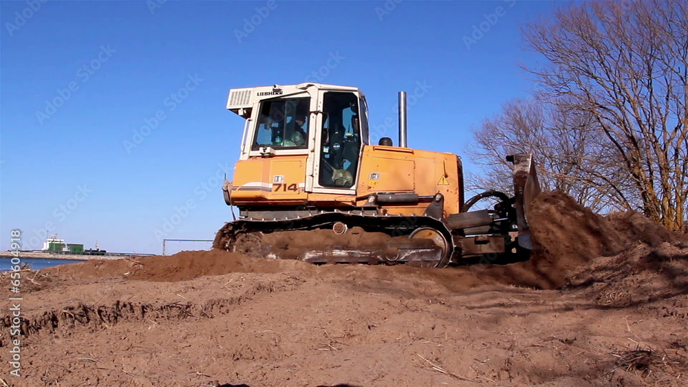 A yellow bulldozer grabbing some soil A yellow bulldozer grabbing some soil
