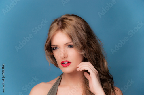 sexy woman looking thoughtful on blue background