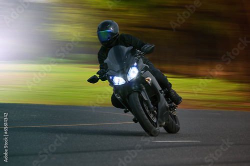 young man riding big bike motorcycle on asphalt high way against