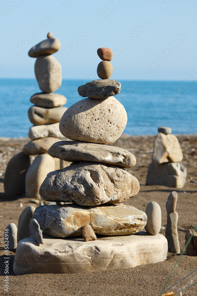 balanced stones, pebbles stacks against blue sea balanced stones, pebbles stacks against blue sea