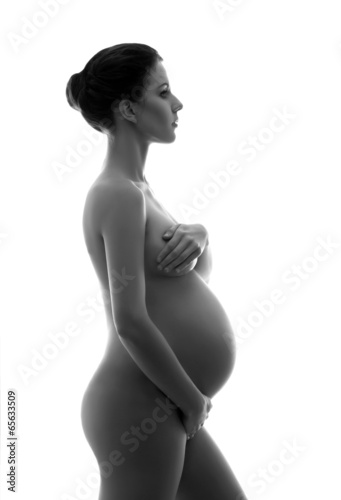 Naked pregnant woman with a beautiful belly on white