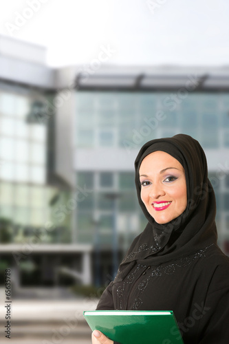 Arabic woman, traditional dressed, in front of office