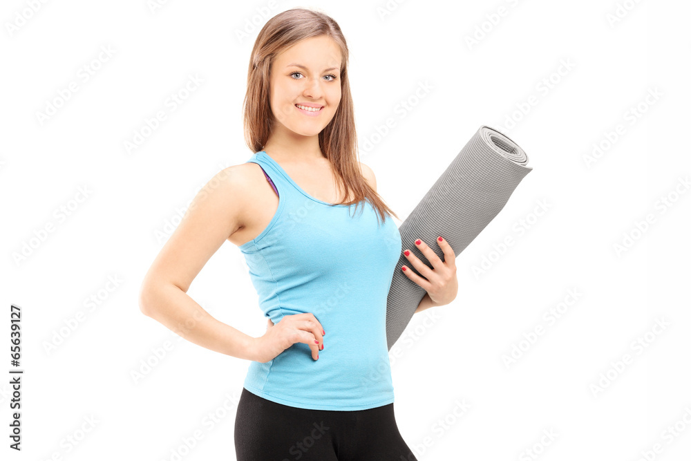 Naklejka premium Attractive woman holding an exercise mat