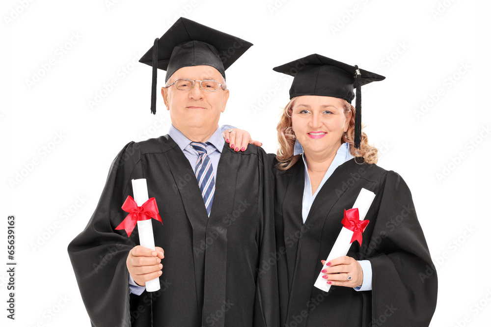 Mature couple in graduation gowns with diplomas Mature couple in graduation gowns with diplomas