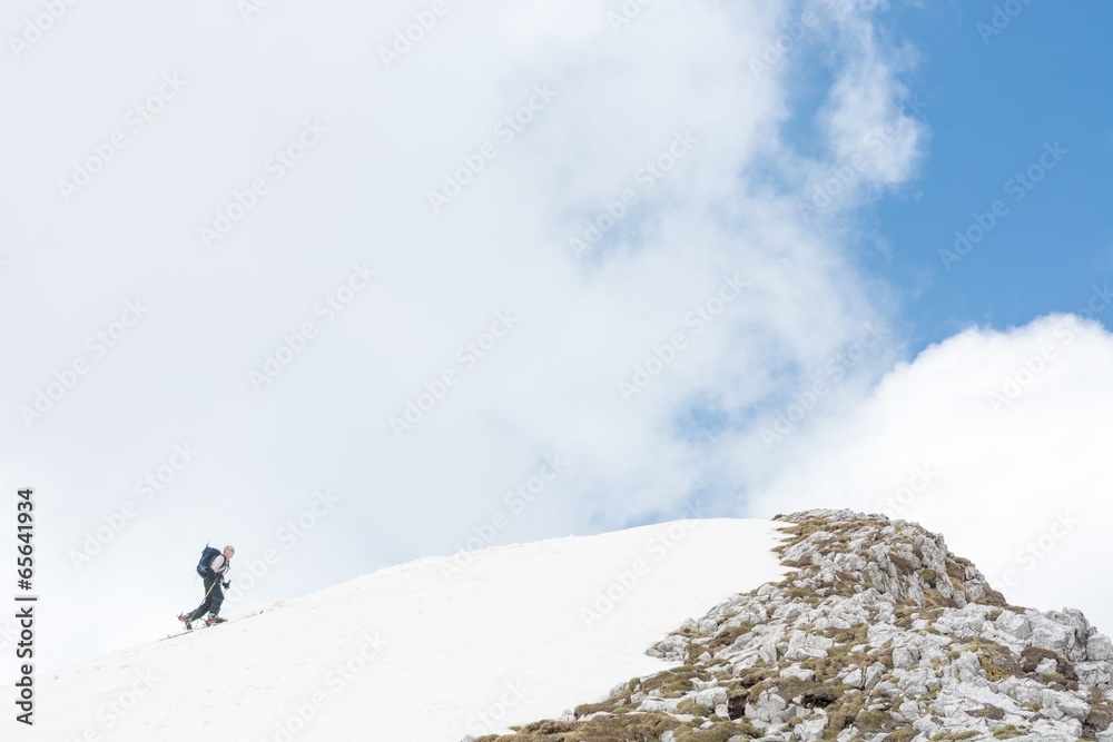 Skiier reaching mountain top