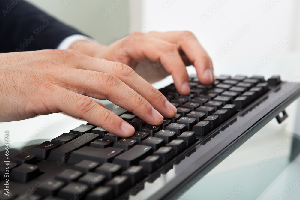 Businessman Using Computer Keyboard At Desk Businessman Using Computer Keyboard At Desk