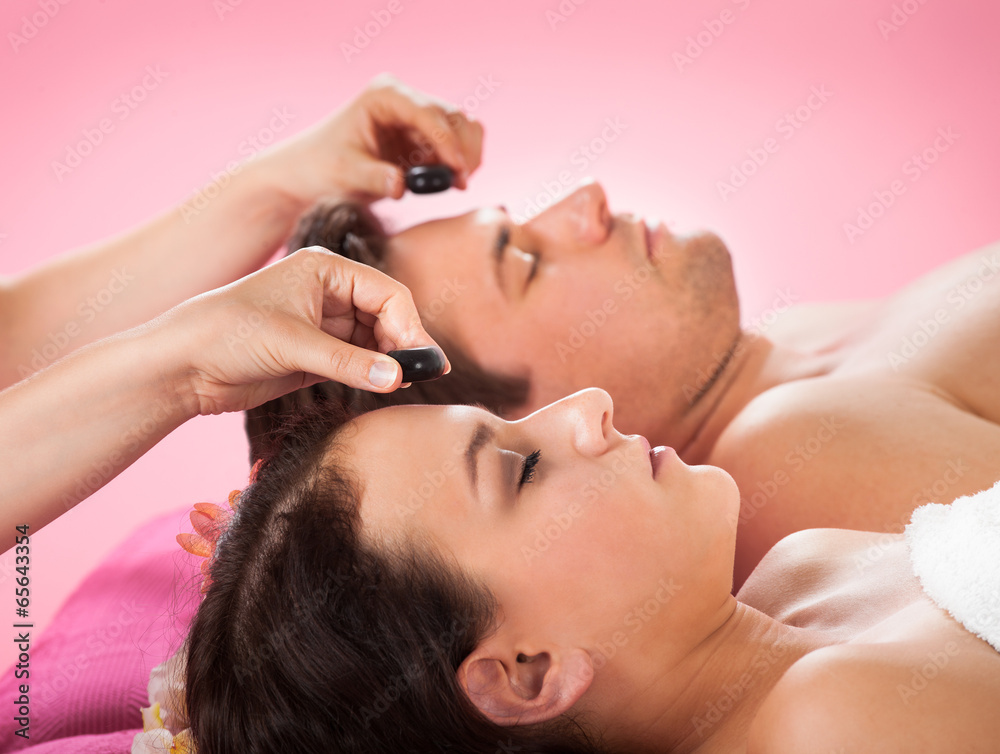 Fototapeta premium Couple Receiving Hot Stone Massage At Spa