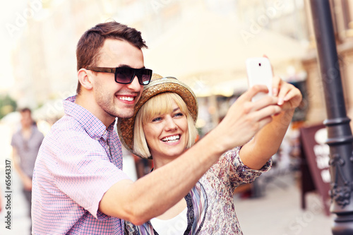 Happy couple taking a picture of themselves while sightseeing
