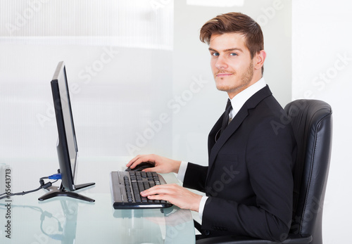 Businessman Using Computer At Office Desk
