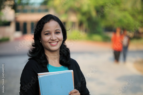 Happy young female student at college campus