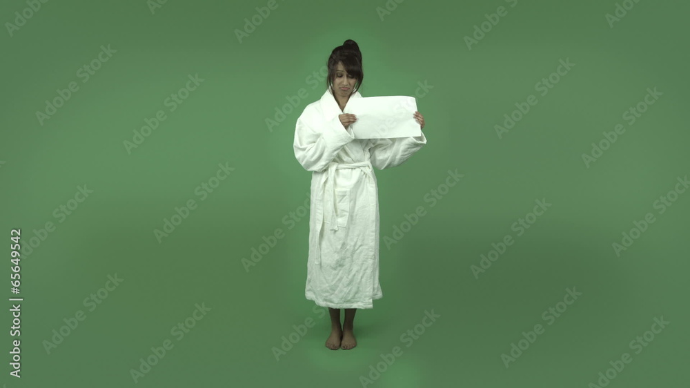 indian woman in bathrobe isolated on green upset with blank sign