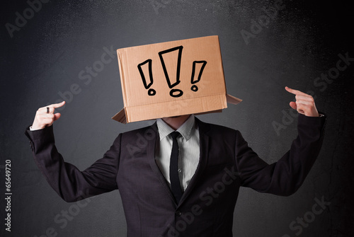 Businessman gesturing with a cardboard box on his head with excl photo