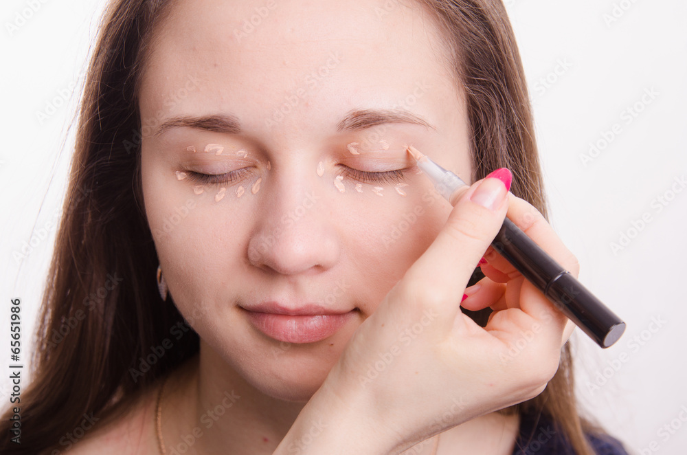 Makeup artist applies foundation on eyelids Makeup artist applies foundation on eyelids