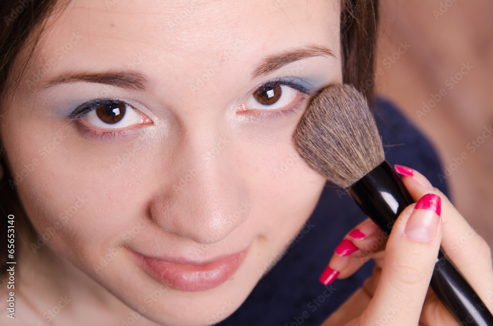Makeup artist applies powder on face of beautiful girl Makeup artist applies powder on face of beautiful girl