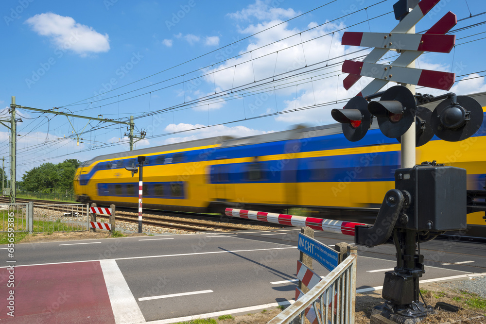 Fotografie Train riding over a rail crossing in spring