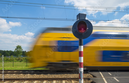 Fotografie Train riding over a rail crossing in spring