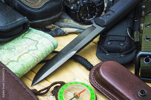 Knife surrounded by tourist equipment