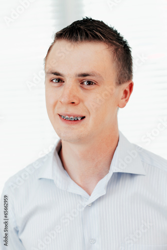 Smiling young man with orthodontic braces. © BRIAN_KINNEY